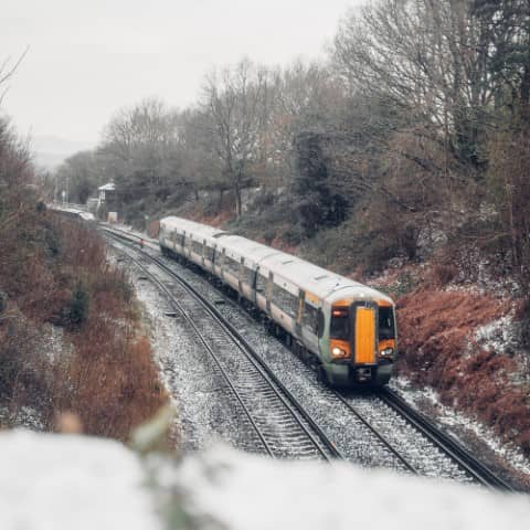 A train on snowy tracks in a winter landscape.